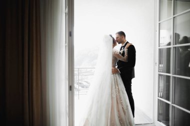 Güzel gelin ve damat düğün günlerinde kucaklaşıp öpüşürler.