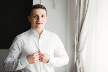 Güzel adam, damat poz veriyor ve düğüne hazırlanıyor.