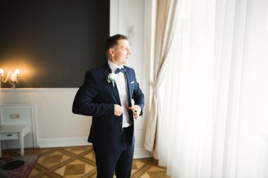 Güzel adam, damat poz veriyor ve düğüne hazırlanıyor.