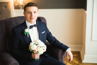 Güzel adam, damat poz veriyor ve düğüne hazırlanıyor.