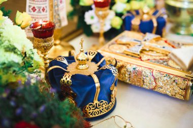 Kilisedeki masanın üzerinde altın taçlar var.