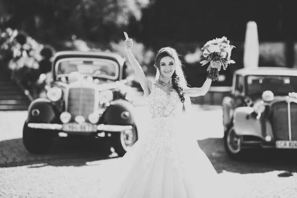 Lyx bröllop brud, flicka poserar och ler med bukett — Stockfoto