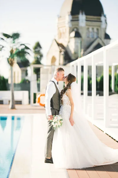 Güzel gelin ve damat düğün günlerinde kucaklaşıp öpüşürler. — Stok fotoğraf