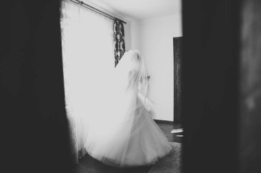 Lüks bir gelin, bir kız buketle poz veriyor ve gülümsüyor.