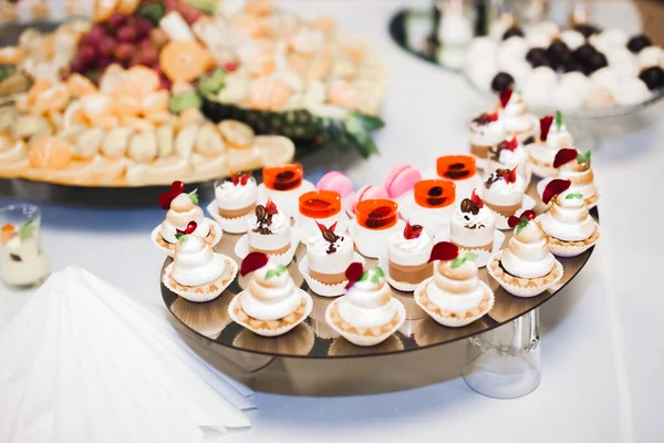 Deliciosa y sabrosa mesa de postres con cupcakes y tomas en la recepción de primer plano — Foto de Stock