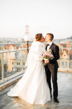 Güzel gelin ve damat düğün günlerinde kucaklaşıp öpüşürler.