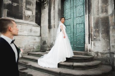 Güzel, mutlu bir düğün çifti, güzel şehirde uzun beyaz elbiseli bir gelin.