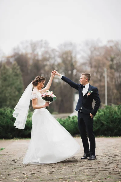 Heureux beaux jeunes mariés dansant dans le parc — Photo