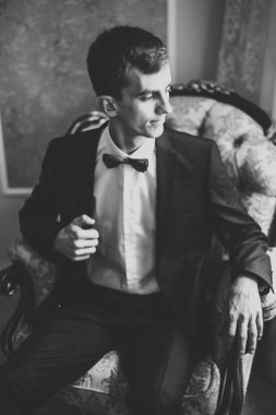 Güzel adam, damat poz veriyor ve düğüne hazırlanıyor.