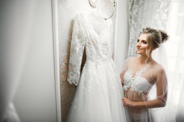 Beyaz elbiseli lüks gelin düğün törenine hazırlanırken poz veriyor.