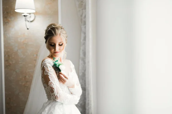 Noiva de luxo em vestido branco posando enquanto se prepara para a cerimônia de casamento — Fotografia de Stock