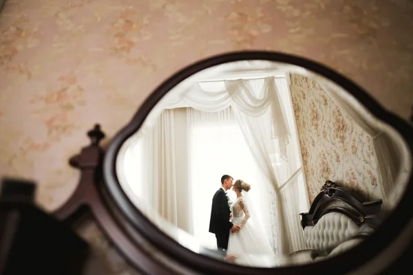 Beautiful bride and groom embracing and kissing on their wedding day — Stock Photo, Image