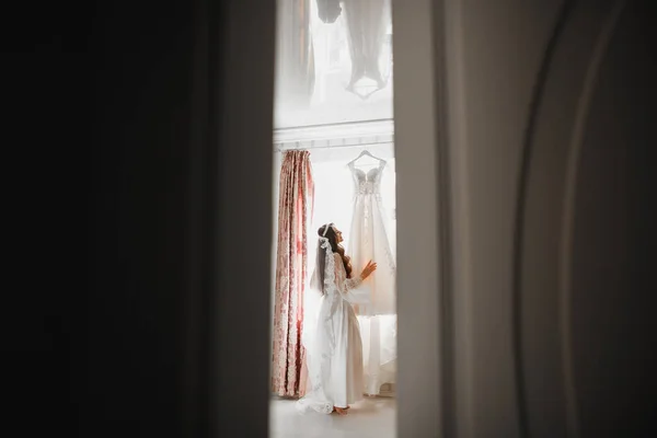 Όμορφη νύφη φορώντας νυφικό μόδας με φτερά με πολυτέλεια απόλαυση make-up και χτένισμα, στούντιο εσωτερική φωτογράφιση — Φωτογραφία Αρχείου