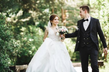 Botanik parkında yürüyen mutlu bir çift.