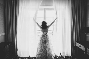 Cüppeli muhteşem gelin bir odada düğün töreni için poz veriyor ve hazırlanıyor.