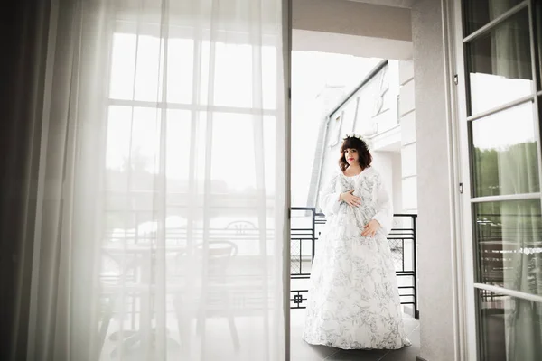 Linda noiva em roupão posando e se preparando para o rosto cerimônia de casamento em uma sala — Fotografia de Stock