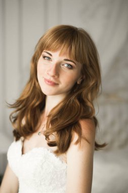 Beyaz elbiseli lüks gelin düğün törenine hazırlanırken poz veriyor.