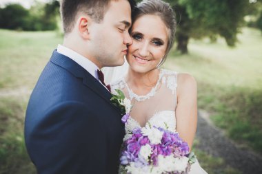 Bahar mevsiminde öpüşen düğün çifti. Yakın plan portre.