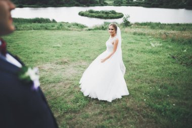 Yeni evli çift el ele tutuşurken parkta koşup zıplıyorlar.