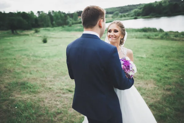 Tökéletes pár menyasszony, vőlegény pózol és csók az esküvő napján — Stock Fotó