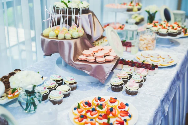 Deliciosos dulces en el buffet de dulces de boda con postres, cupcakes — Foto de Stock