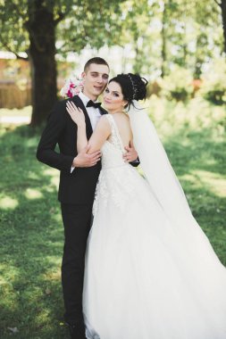 Yeni evli çift el ele tutuşurken parkta koşup zıplıyorlar.