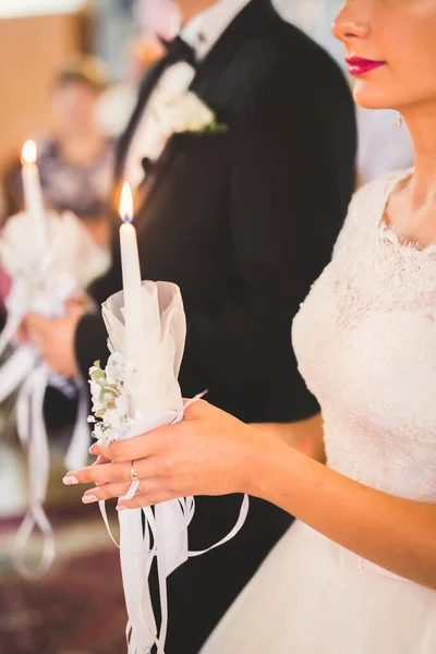 Noiva e noivo segurando velas na igreja — Fotografia de Stock