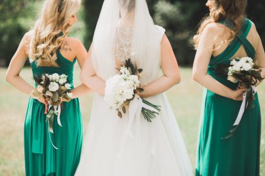 Gelin çiçekli büyük ve güzel bir düğün buketi tutuyor.