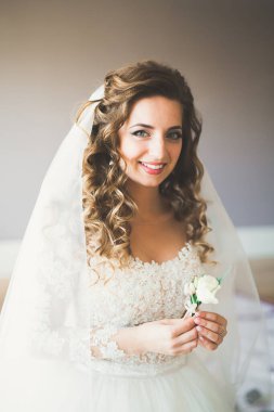 Beyaz elbiseli lüks gelin düğün törenine hazırlanırken poz veriyor.