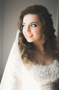 Beyaz elbiseli lüks gelin düğün törenine hazırlanırken poz veriyor.