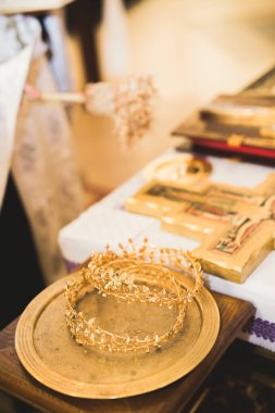 Kilisedeki masanın üzerinde altın taçlar var.