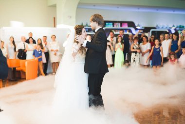 Güzel beyaz bir çift yeni evlendiler ve ilk danslarını ediyorlar.