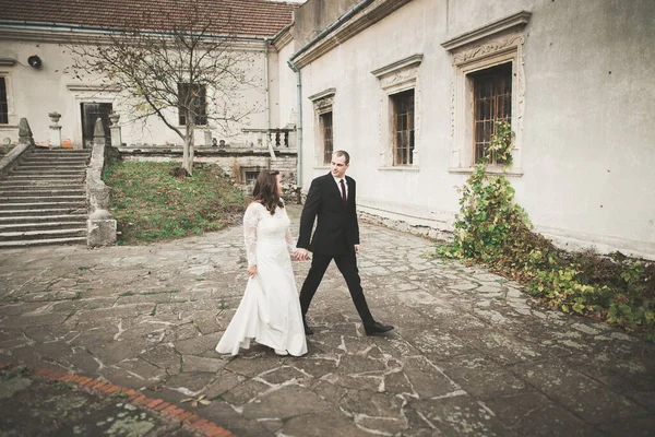 Güzel, romantik bir düğün. Yeni evliler. Eski kalenin yakınlarında sarılıyorlar. — Stok fotoğraf