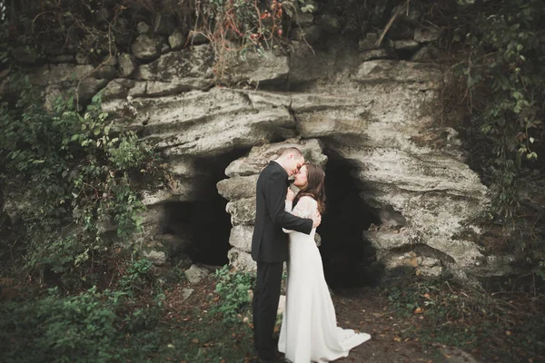 Schönes junges Hochzeitspaar küsst und lächelt im Park — Stockfoto