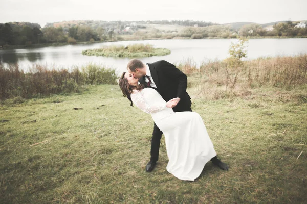 Pareja perfecta novia, novio posando y besándose en el día de su boda — Foto de Stock