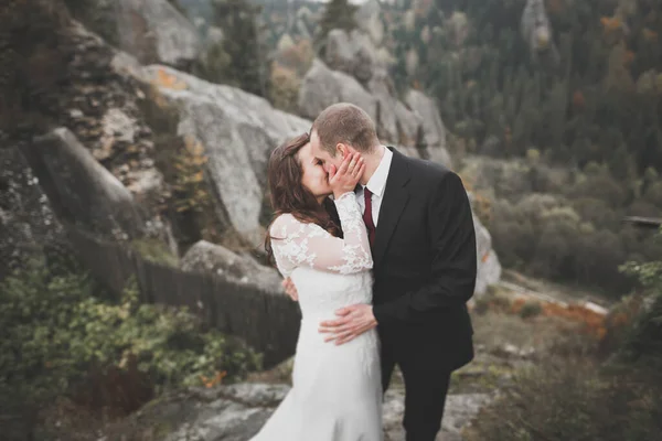 Glad bröllop par poserar över vackra landskap i bergen — Stockfoto
