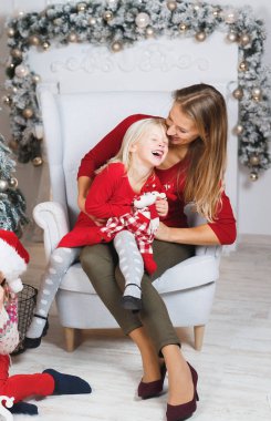 Anne ve kızları küçük kızların doğum günü hediyelerini açıyorlar.