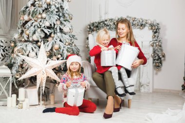 Anne ve çocukları Noel ağacının yanında kutluyorlar.