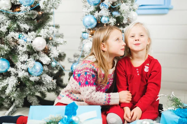 Mutlu küçük çocuklar Noel arifesinde hediyeleri açıyor. — Stok fotoğraf