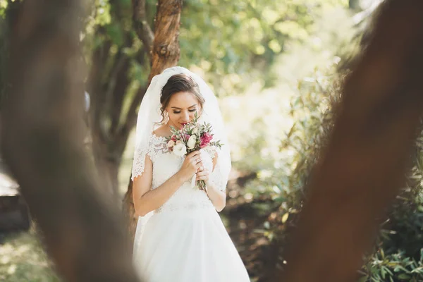 Indah pengantin muda mewah dalam gaun pengantin berpose di taman — Stok Foto