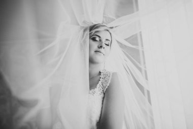 Cüppeli muhteşem gelin bir odada düğün töreni için poz veriyor ve hazırlanıyor.