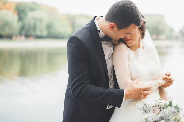 Romantis, dongeng, pasangan pengantin baru yang bahagia memeluk dan mencium di taman, pohon di latar belakang — Stok Foto