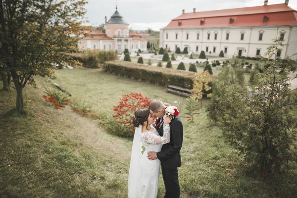 아름다운 낭만적 인 신혼 부부들 이 오래 된 성 근처에서 포옹하고 있다 — 스톡 사진