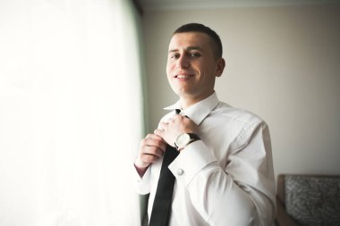 Güzel adam, damat poz veriyor ve düğüne hazırlanıyor.