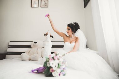 Beyaz elbiseli lüks gelin düğün törenine hazırlanırken poz veriyor.