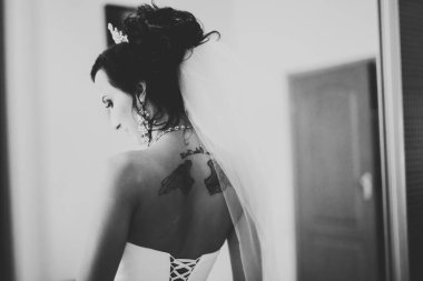 Cüppeli muhteşem gelin bir odada düğün töreni için poz veriyor ve hazırlanıyor.