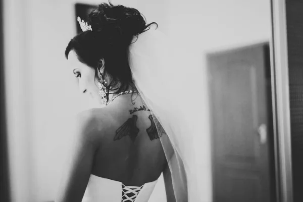 Nádherná nevěsta v županu pózuje a připravuje se na svatební obřad tvář v místnosti — Stock fotografie