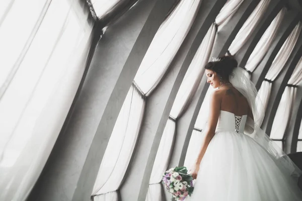 Ritratto di splendida sposa con capelli lunghi in posa con grande bouquet — Foto Stock