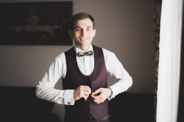 Güzel adam, damat poz veriyor ve düğüne hazırlanıyor.