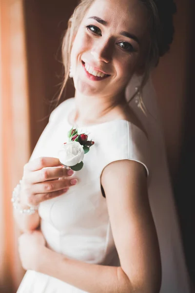 Hermosa novia con vestido de novia de moda con plumas con maquillaje de lujo deleite y peinado, estudio sesión de fotos interior —  Fotos de Stock